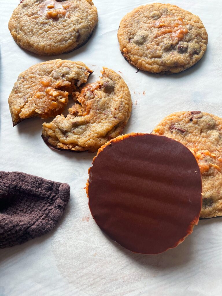 Chokladdoppade cookies med jordnötskola, en cookie bruten i bitar med seg kolafyllning