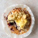 Blåbärsmuffins med vaniljkräm och smuldeg i en vit muffinsform